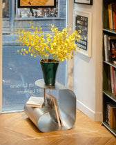 Vase vert au bouquet jaune sur une Table d'appoint Gégé Inox brossé, rayonnages de La Hune