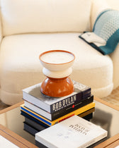Bougie TamTam Twist Narguillé posée sur une pile de livres d'art, table basse et canapé bouclé écru