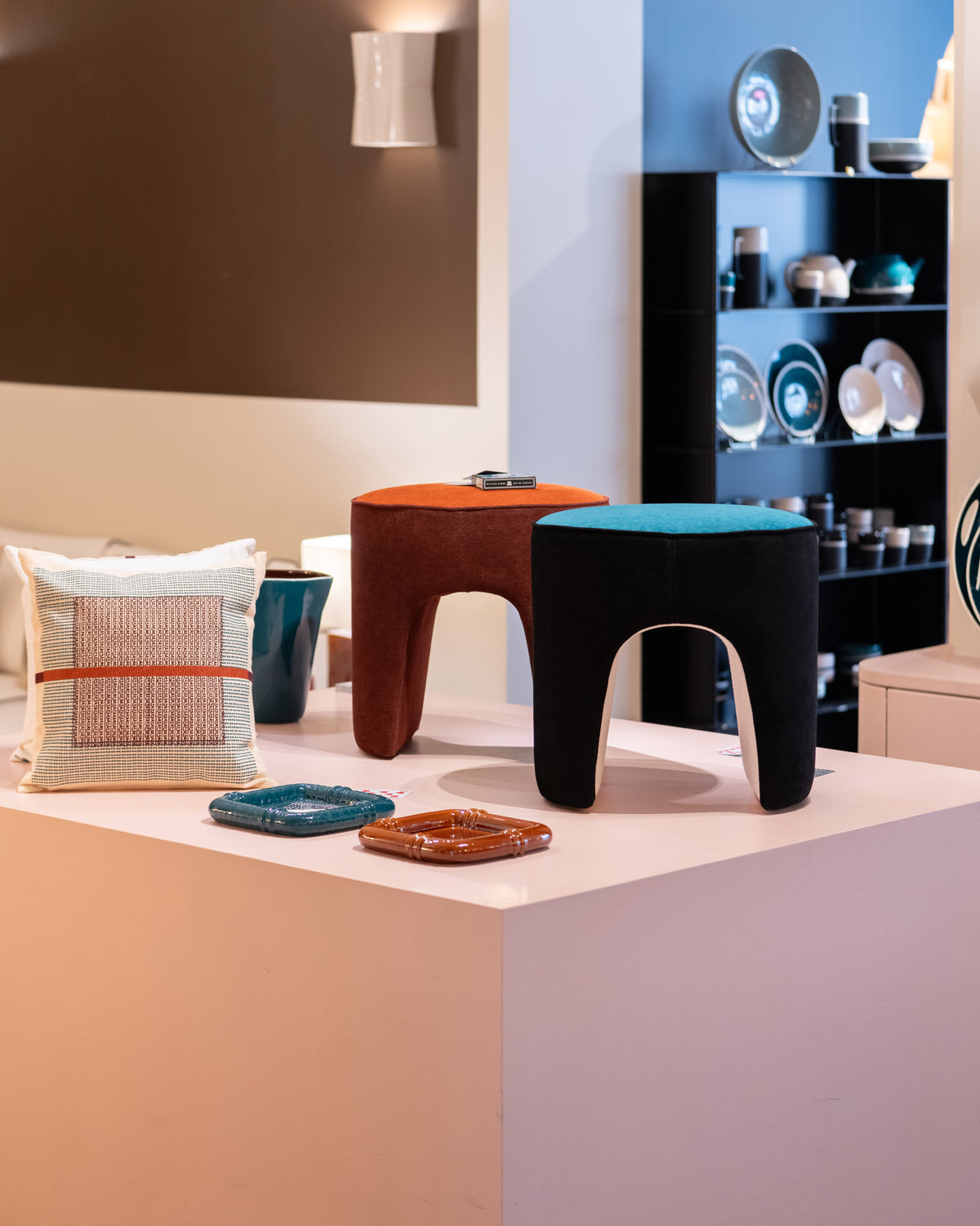 Poufs Léa Tangerine et Bleu Sarah sur un podium rose avec Coussin Nil et Vide-poches Coco