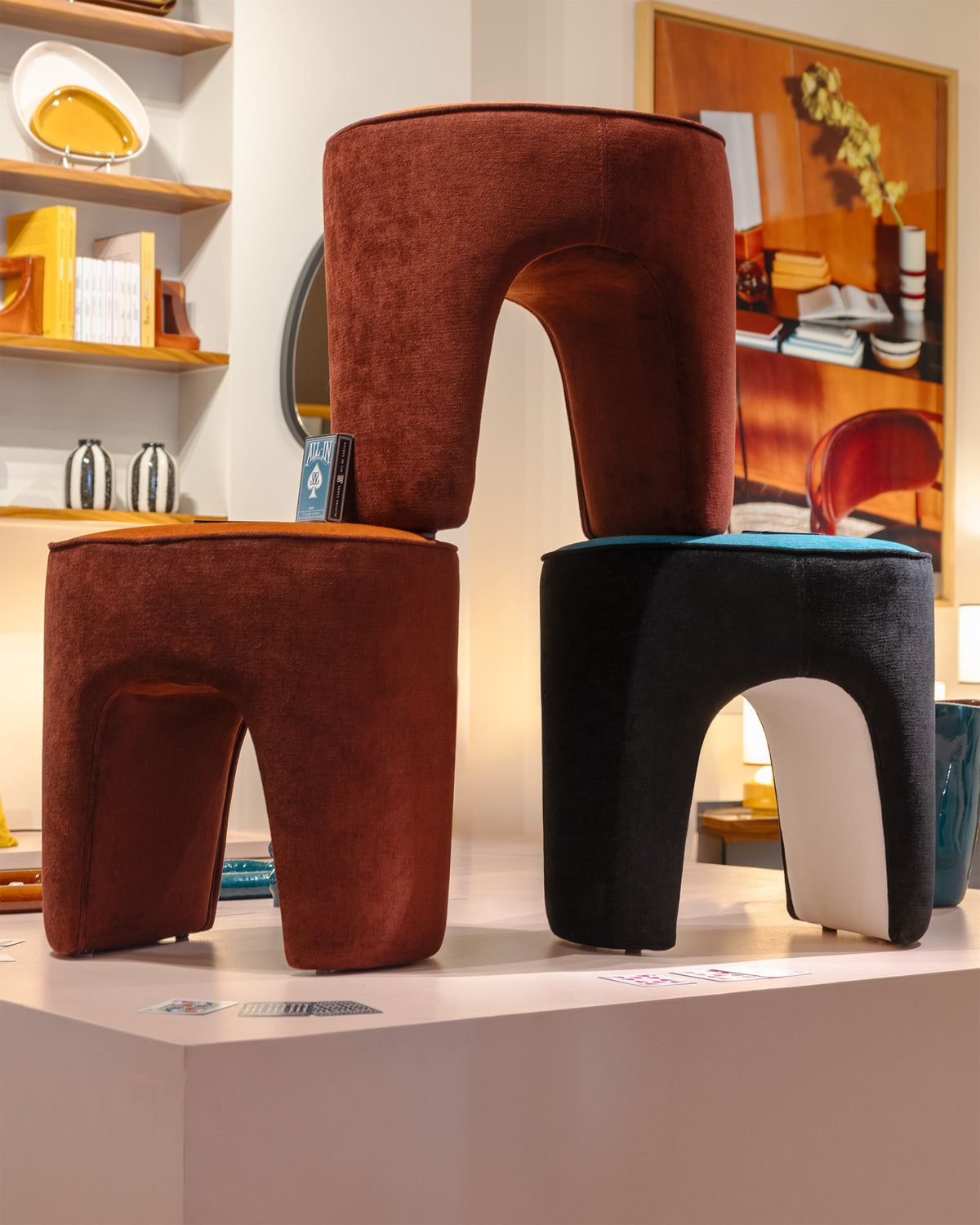 Poufs Léa Tangerine et Bleu Sarah en équilibre sur un podium de la boutique, cadrage serré